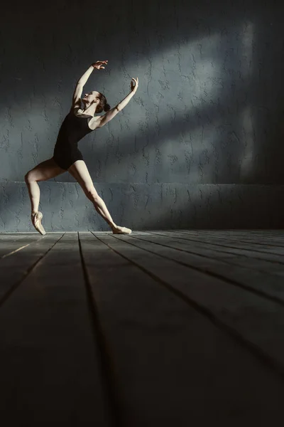 Χαρισματικός νεαρός μπαλέτου χορευτής κατάρτισης στο μαύρο χρωματισμένο δωμάτιο — Φωτογραφία Αρχείου
