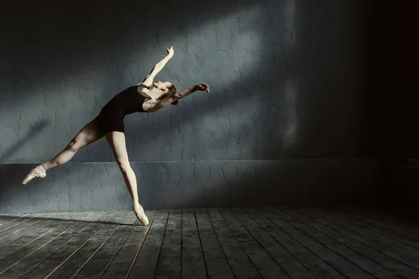 Gekonnte junge Balletttänzerin, die im schwarzen Raum agiert — Stockfoto