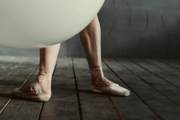 Patas de bailarina de ballet ensensensed ubicadas en la habitación de color negro —  Fotos de Stock