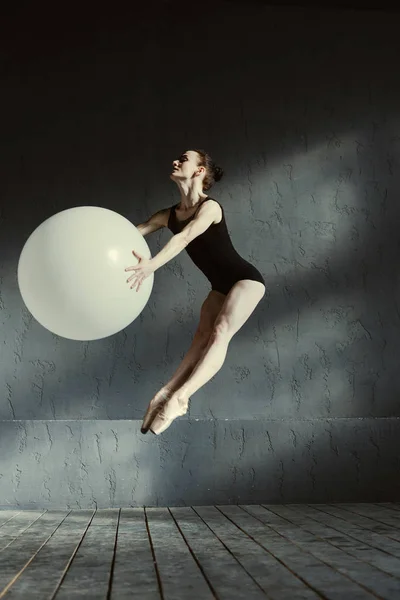 Esnek karizmatik jimnastikçi beyaz balon kullanarak gerçekleştirme — Stok fotoğraf