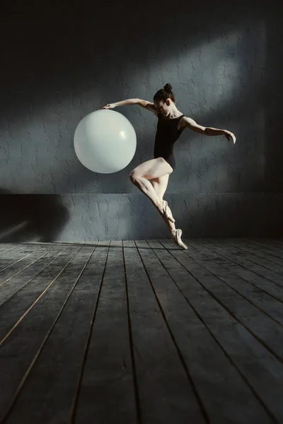 Грамотний гімнаст розтягується за допомогою білої кулі — стокове фото