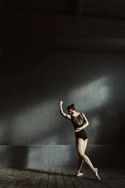 Joven gimnasta bailando en la habitación con luz oscura —  Fotos de Stock
