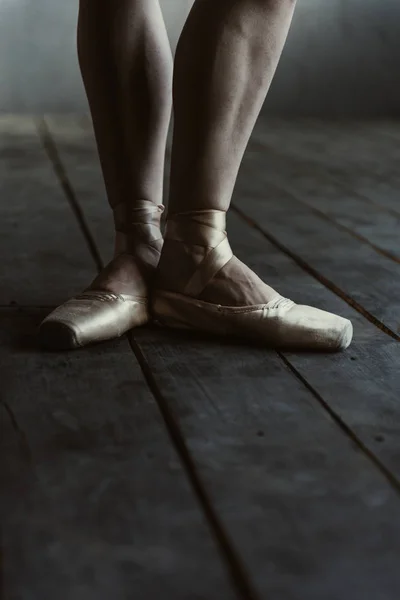 Pernas dançarinas de balé em pointes em pé no chão preto — Fotografia de Stock