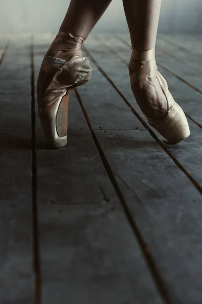 Артистка балета, растянувшаяся на цыпочках в черной студии — стоковое фото