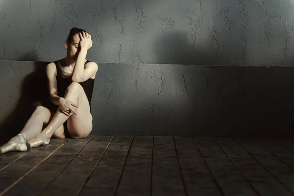 失望的芭蕾舞演员坐在黑暗的点燃房间 — 图库照片