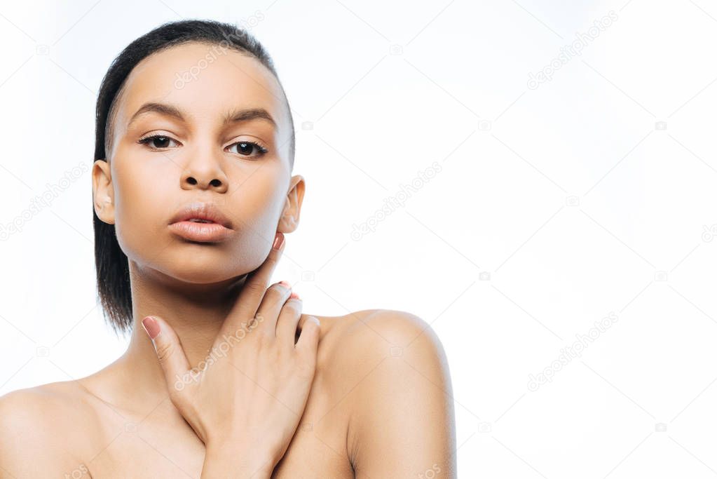 Graceful young Negroid woman expressing charm in the studio