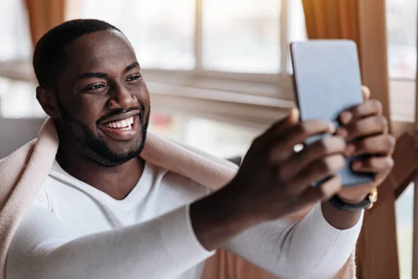 Счастливый афроамериканец общаться с помощью гаджета — стоковое фото