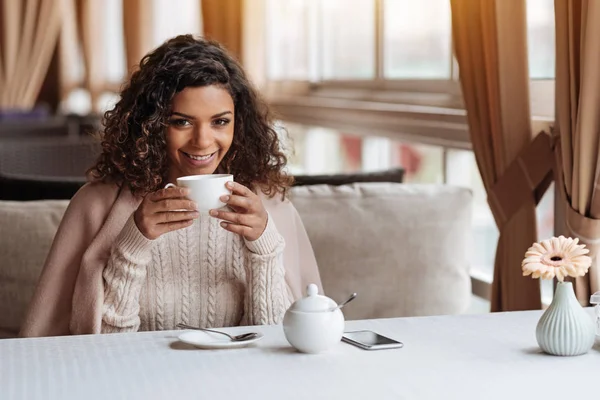 Улыбающаяся афроамериканка пьет чашку чая — стоковое фото