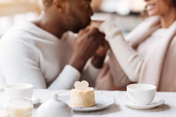 Hilarante pareja afroamericana cogida de la mano en el café —  Fotos de Stock