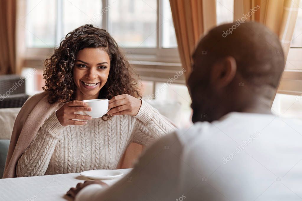 Cheerful African American couple having conversation in the cafe