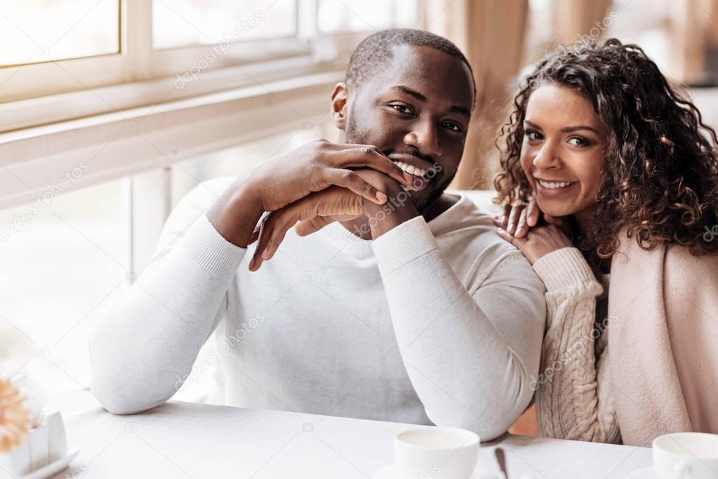 Joyous African American couple sitting in the cafe