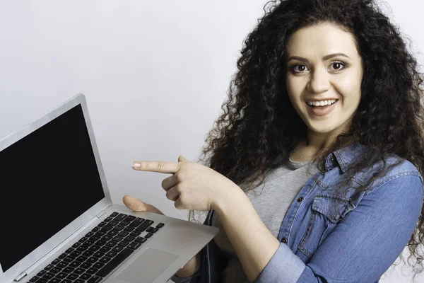 Smiling girl advertising a laptop. — Stock Photo, Image