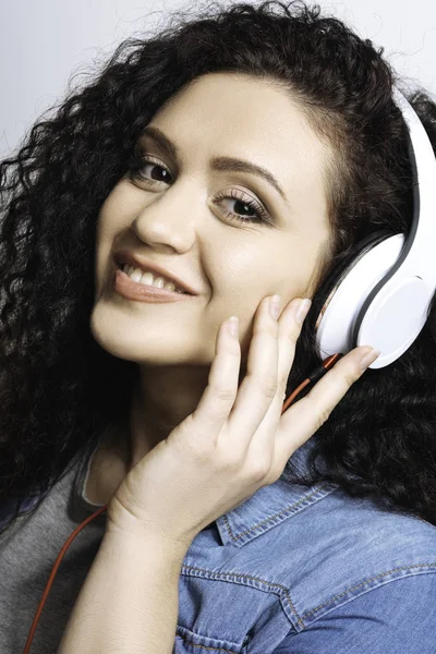Satisficed looking girl correcting earphones — Stock Photo, Image