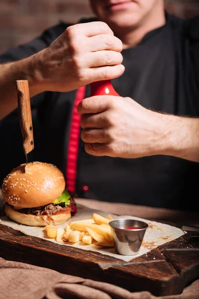 Glimlachende man voorbereiden om te eten van de hamburger en frietjes — Stockfoto
