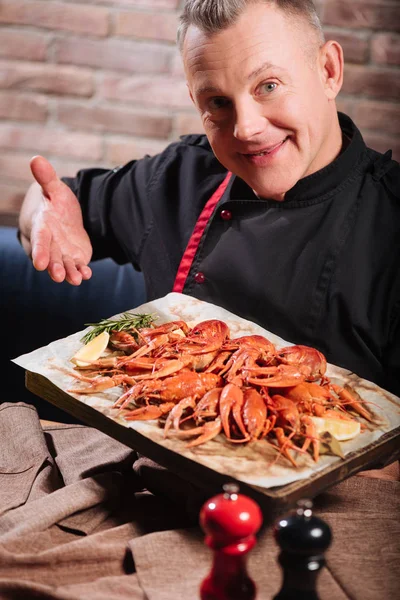 Overjoyed man demonstrating a tray full of crayfishes — Stock Photo, Image