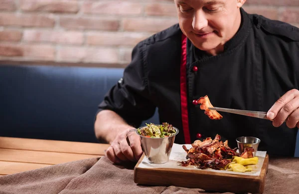 Koncentrerad mannen äter bacon i restaurang — Stockfoto