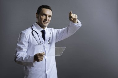 Bir yere işaret parmağıyla memnun doktor