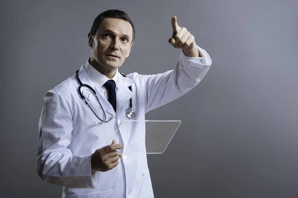 Knappe dokter ergens met zijn vinger wijzend — Stockfoto