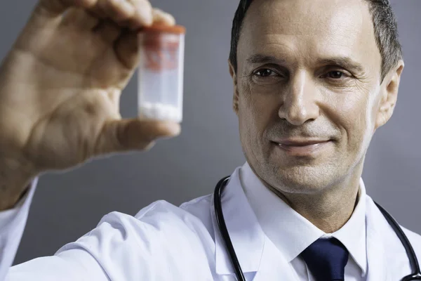 Närbild av koncentrerad läkare håller låda med tabletter — Stockfoto