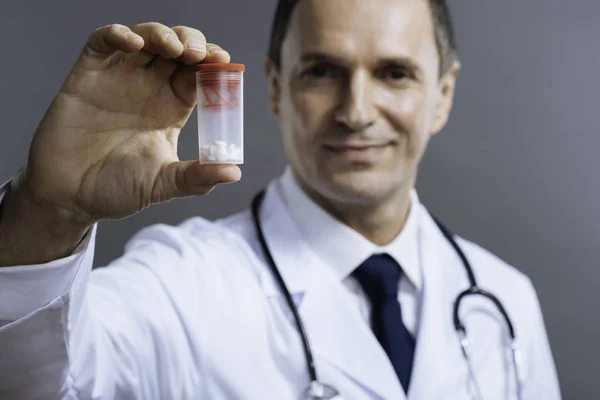 Close up of handsome doctor holding box with medicine — Stock Photo, Image