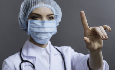 Güzel doktor gri arka plan üzerinde el hareketi