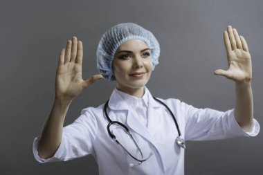 Kadın doktor eller gri arka plan üzerine koyarak.