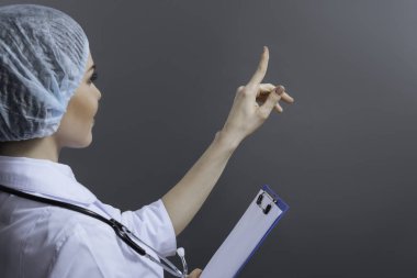 Bir yere işaret parmağıyla çekici kadın doktor