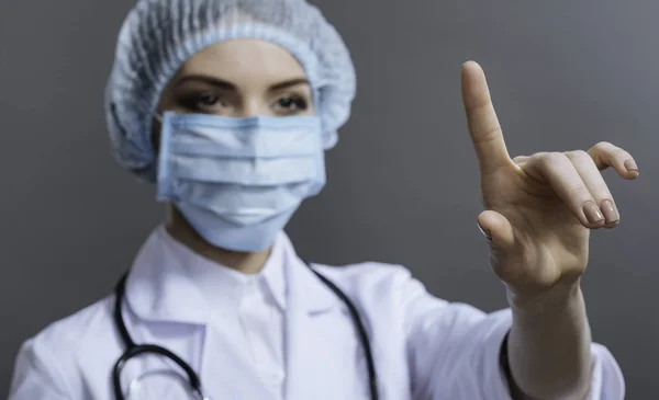 Grazioso medico gesticolando su sfondo grigio — Foto Stock