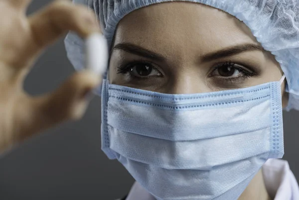 Close up of pretty doctor looking at pill — Stock Photo, Image