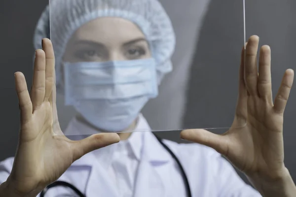 Medico femminile che guarda attraverso il vetro medico — Foto Stock