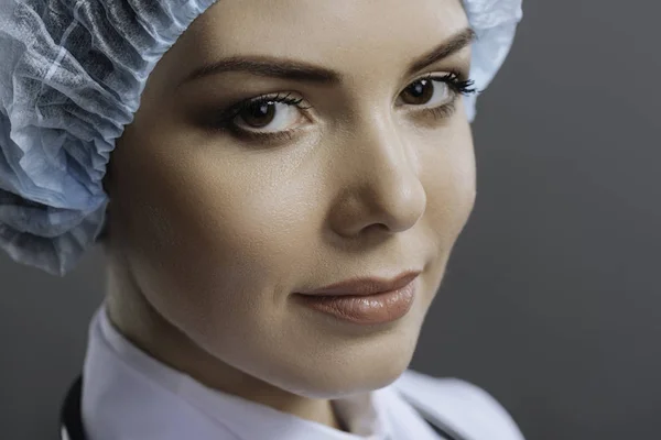 Portrait de femme médecin enchantée posant sur fond gris — Photo