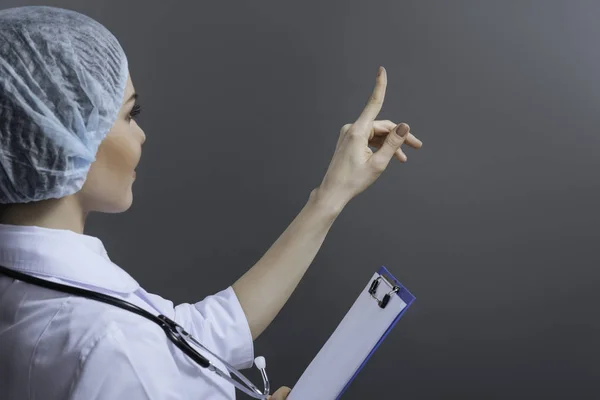 Attractive female doctor pointing somewhere with her finger — Stock Photo, Image