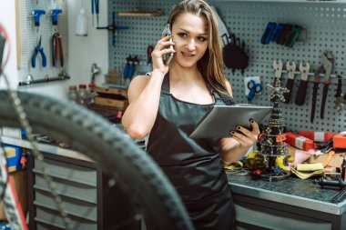 Gülümseyen genç craftswoman onarımları araçları kullanma