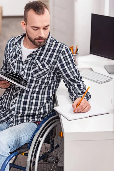 Hombre discapacitado guapo tomando notas — Foto de Stock
