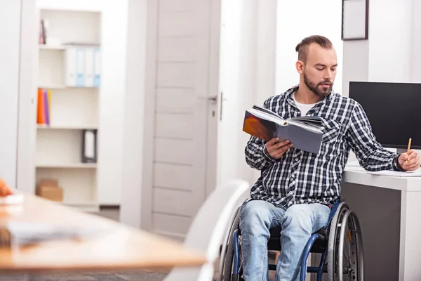 Inteligentny facet niepełnosprawnych wydatków, jego wolnego czasu studiowania — Zdjęcie stockowe