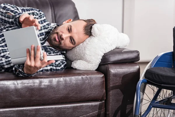 Relajado chico discapacitado mirando a través de un álbum — Foto de Stock