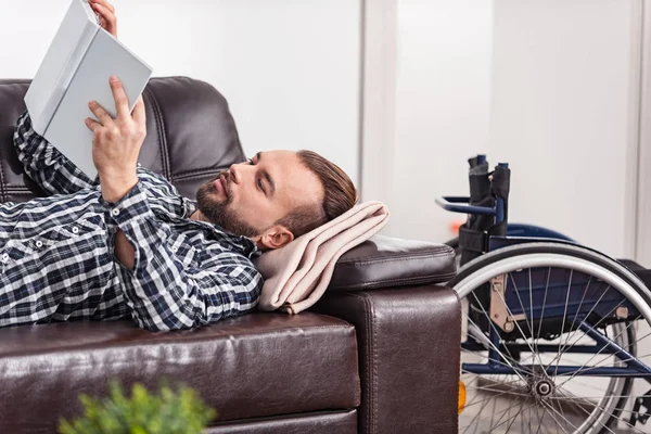 Relajado discapacitado hombre pasando páginas de un libro — Foto de Stock