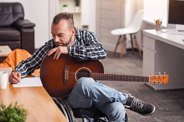 Fokuserade handikappade mannen ägnar sig åt låtskrivande — Stockfoto