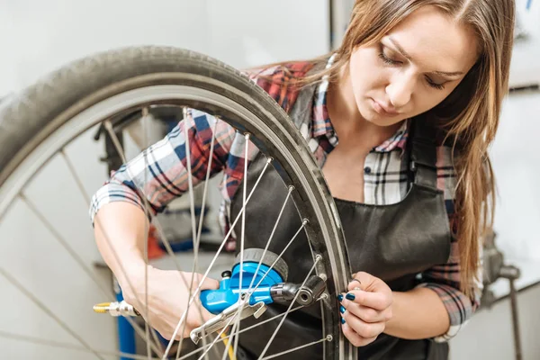 Koncentrovaný craftswoman měření tlaku pneumatik — Stock fotografie