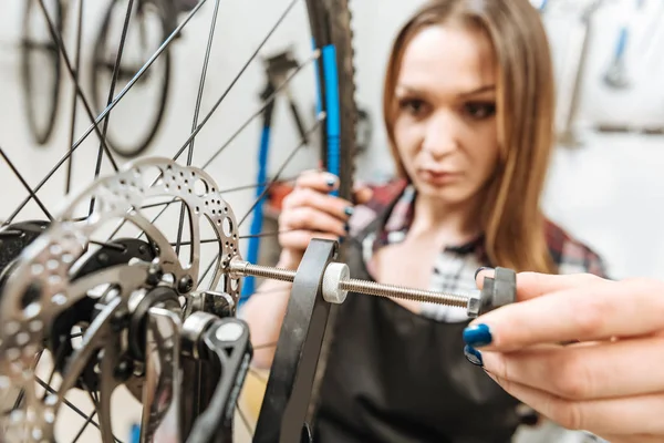 Vrouwelijke technicus rehabbing het wiel in de werkplaats — Stockfoto