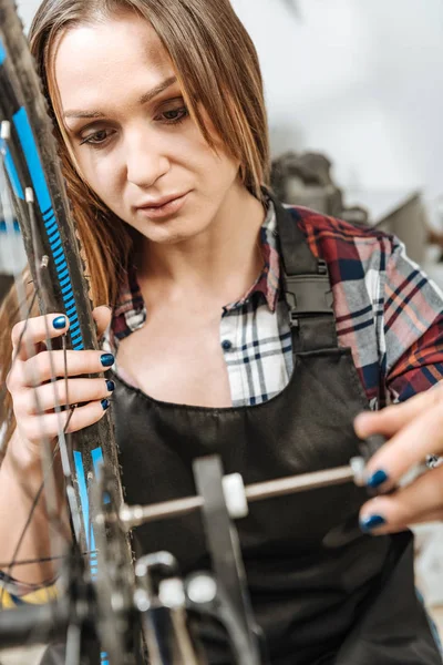 Involverade unga hantverkerska reparera cykeln i garaget — Stockfoto