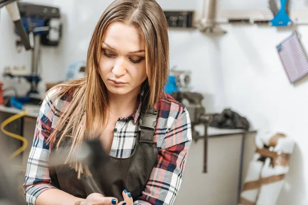 Trabajador joven serio sentado en el taller de reparación — Foto de Stock