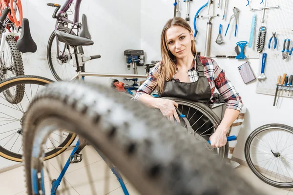 Fröhliche junge Handwerkerin arbeitet in der Garage — Stockfoto