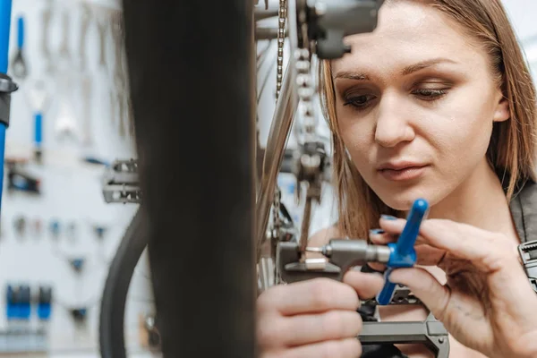 Hårt arbetande ung tekniker fastställande pedalen av cykel — Stockfoto
