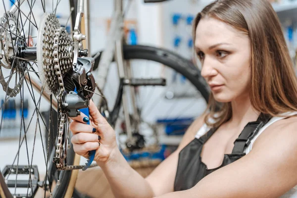 Inblandade kvinnlig mekaniker reparera kedjan av cykeln — Stockfoto