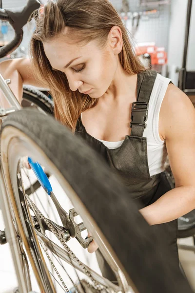 Tankeväckande kvinnliga tekniker fastställande pedalen i verkstaden — Stockfoto