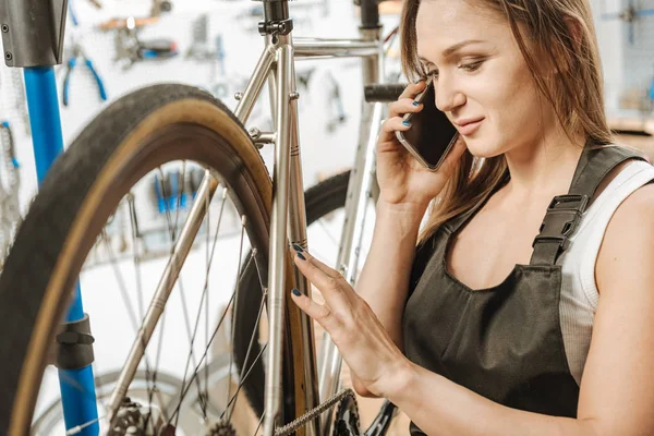 Positiv arbetare reparera cykeln och prata över telefon — Stockfoto