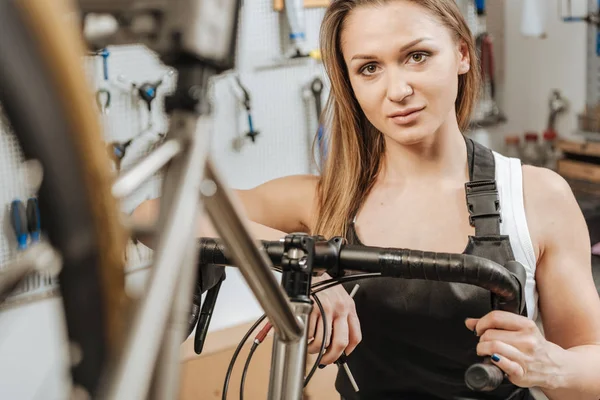 Glada mekaniker reparerar cykeln i verkstaden — Stockfoto