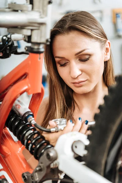 Uppmärksamma unga tekniker reparera cykeln i verkstaden — Stockfoto