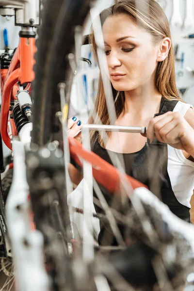 Seriös mekaniker reparerar cykeln i verkstaden — Stockfoto